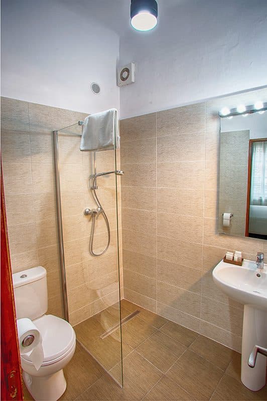 Cabina de duș dintr-o baie de cameră superioară, cu lavoar alături.